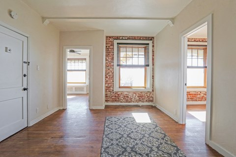 a living room with two windows and a rug